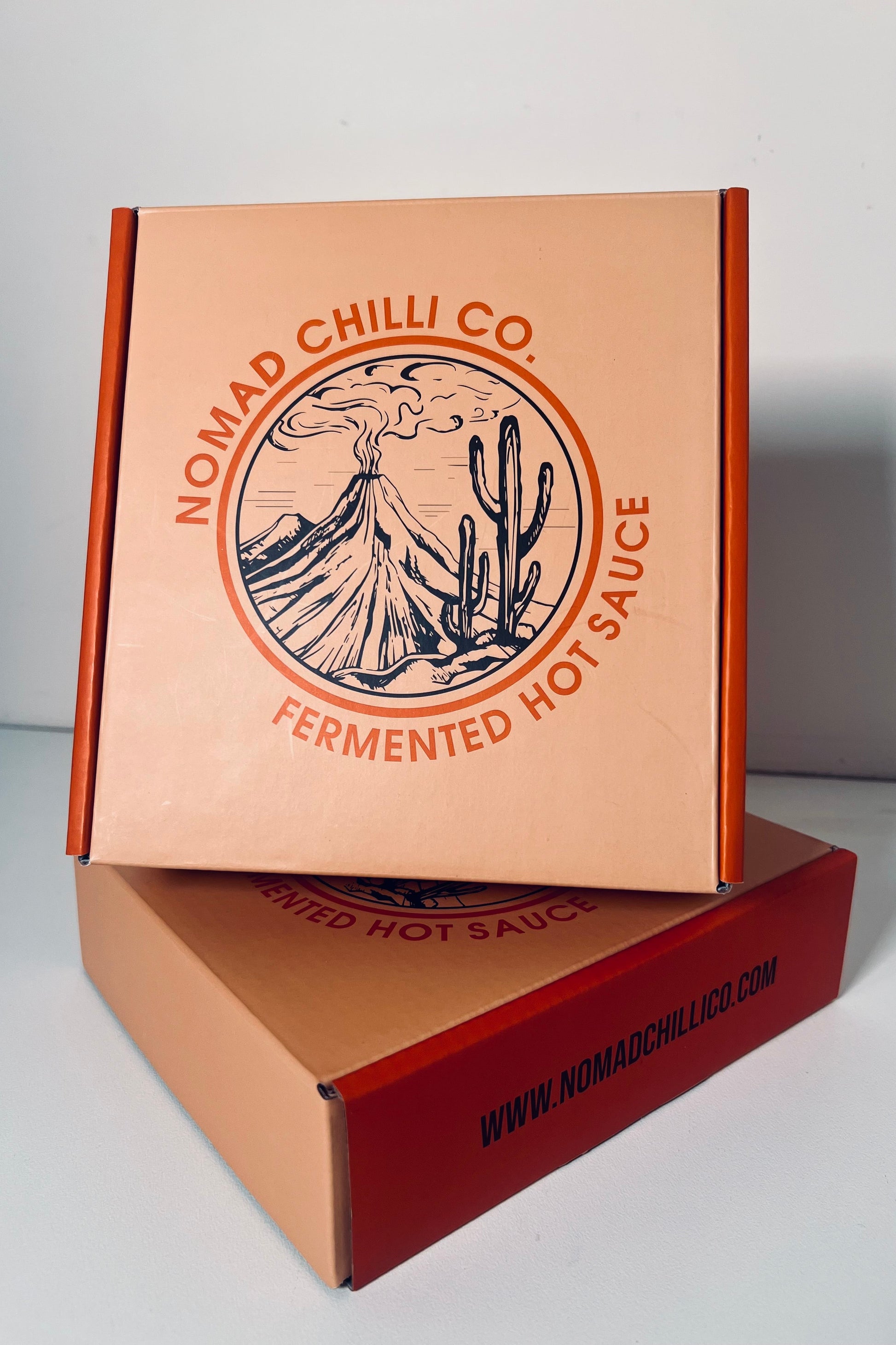 Nomad Chilli Co. cardboard boxes with branding on a white background