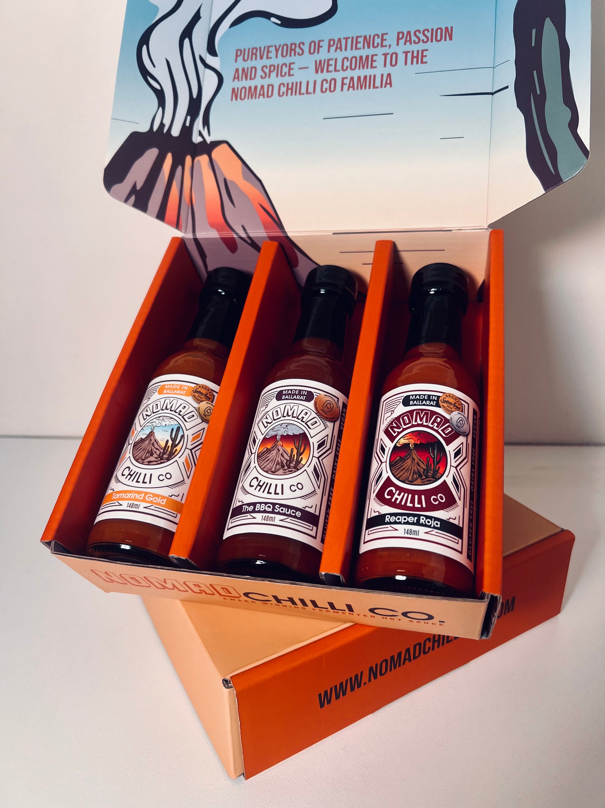 Three bottles of Nomad Chilli Co hot sauce in a branded box on a white background